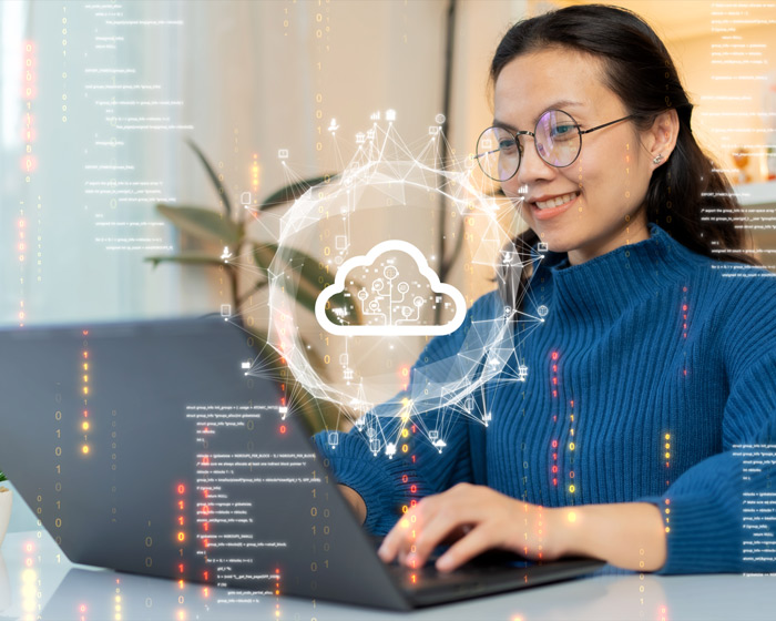 pdf-accessibility Frau mit Laptop arbeitet an Cloud-Lösung – Visualisierung einer Cloud mit Datenströmen im Hintergrund"