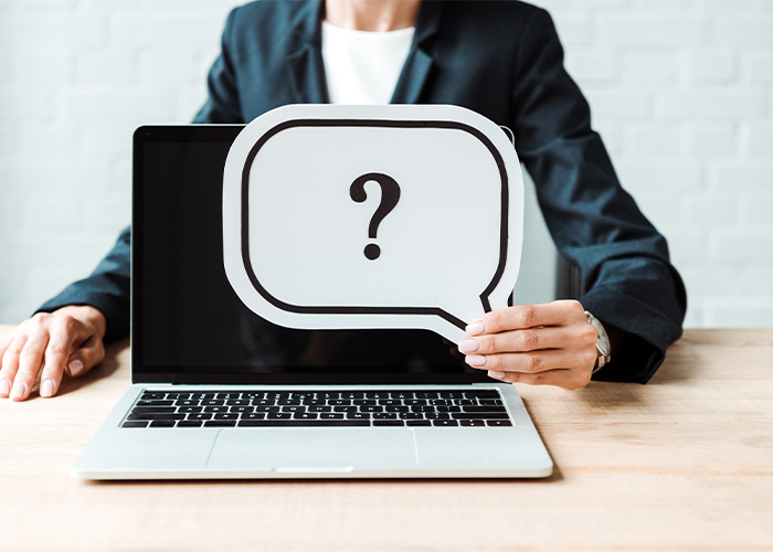 barrierefrei-pdf Person hält ein Laptop mit einem großen Fragezeichen auf dem Bildschirm. Das Bild zeigt, dass viele Menschen nicht wissen, wie ein barrierefreies PDF erstellt wird.