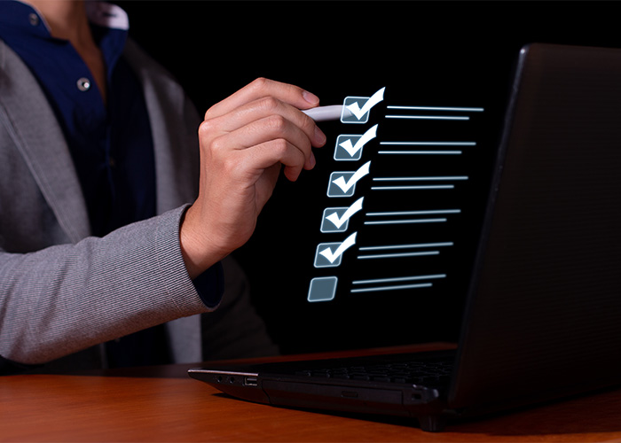 checkliste-pdf Hand berührt einen digitalen Bildschirm mit einer Checkliste und abgehakten Punkten.